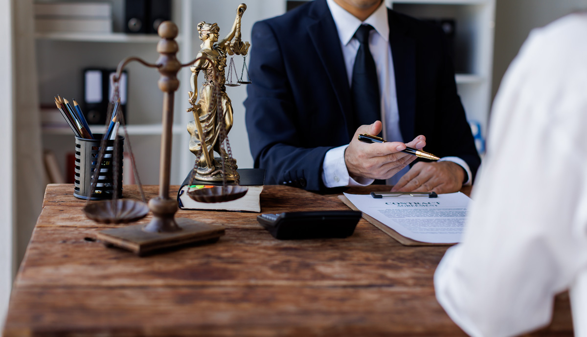 A client and a personal injury lawyer discussing paperwork at a desk.