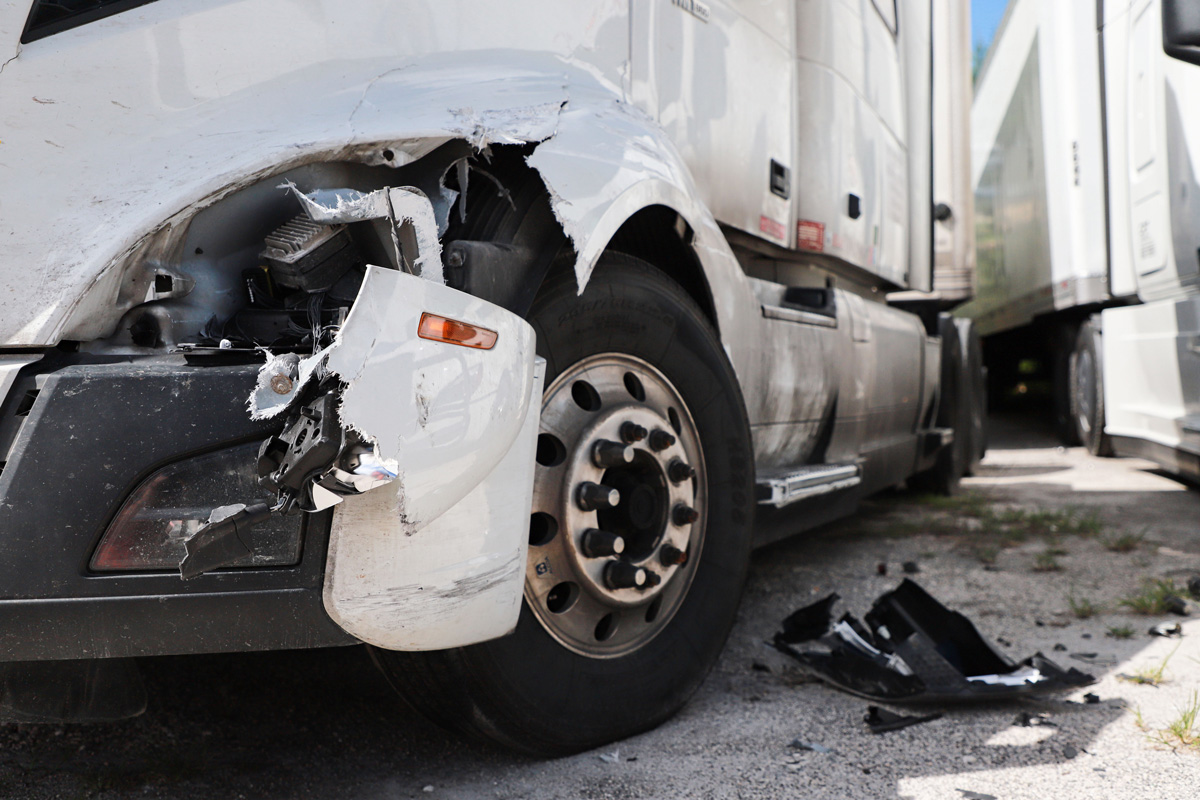 A white semi truck with damage on its front end in El Paso.
