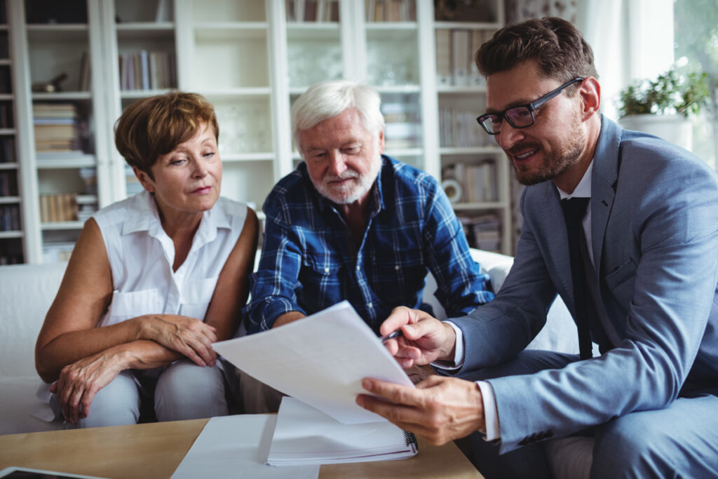 An estate planning lawyer reviewing paperwork with an elderly couple in El Paso.